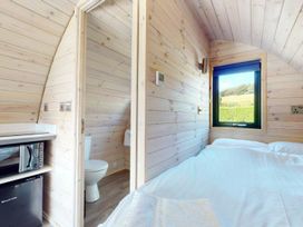 A bedroom with a bed and a bathroom door at Pod 1 (Pet Friendly) in Carnforth