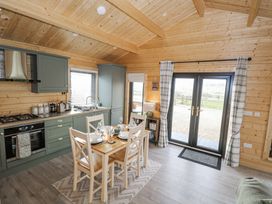 A kitchen with a dining table and four chairs at Glenview Log Cabin in Ballycastle
