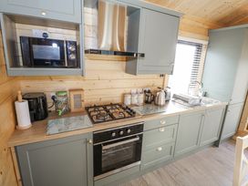 A kitchen with appliances and a sink at Glenview Log Cabin, Ballycastle