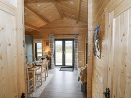 A living room with a dining table and chairs at Glenview Log Cabin in Ballycastle