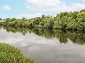 A river with trees and grass by the water at Glenview Log Cabin Ballycastle