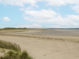 A beach with sand and dunes at Glenview Log Cabin in Ballycastle
