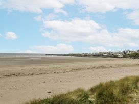 A beach with sand and a view of the sea at Glenview Log Cabin in Ballycastle