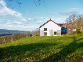 A house with windows and a grassy area at Ty Uchaf in Colwyn Bay