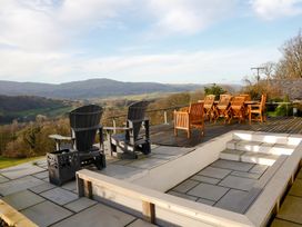 An outdoor area with chairs and a table overlooking a landscape at Ty Uchaf in Colwyn Bay