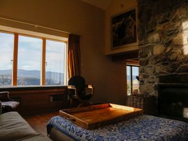 A living room with a rock wall and window view at Ty Uchaf in Colwyn Bay