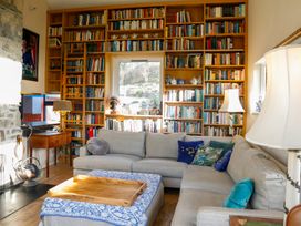 A living room with a bookshelf and sofa at Ty Uchaf in Colwyn Bay