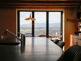 A kitchen with a dining table and large windows at Ty Uchaf in Colwyn Bay