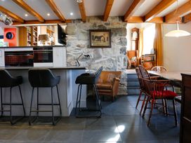 A kitchen with a stone wall and dining area at Ty Uchaf in Colwyn Bay