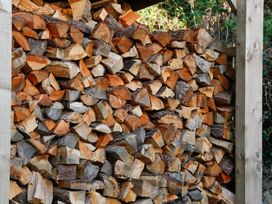 A stack of wooden logs stored in a structure at Ty Uchaf in Colwyn Bay
