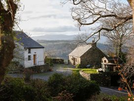 Two buildings with a road and trees at Ty Uchaf in Colwyn Bay
