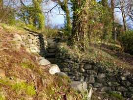 A pathway with stone steps and walls surrounded by greenery at Ty Uchaf in Colwyn Bay