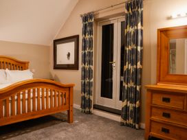 A bedroom with a bed, window, and chest of drawers at Ty Uchaf in Eglwysbach