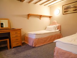 A bedroom with two beds and a desk at Ty Uchaf in Eglwysbach
