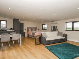 A studio with a bed, sofa, dining area and kitchen at Aloe Lodge in Banham
