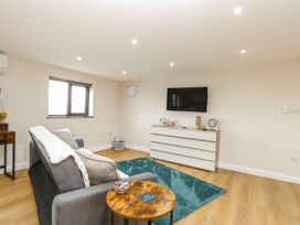 A living room with a sofa and television at Aloe Lodge in Banham