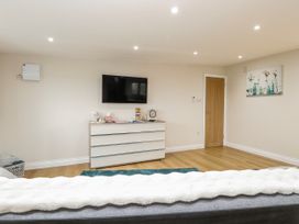 A living room with a television and a door at Aloe Lodge in Banham