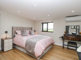 A bedroom with a bed and dressing table at Aloe Lodge Banham