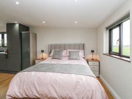 A bedroom with a bed and bedside tables at Aloe Lodge in Banham