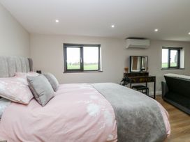 A bedroom with a bed and dressing table at Aloe Lodge in Banham