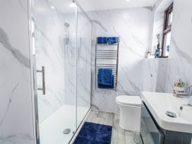 A bathroom with a shower, toilet, and sink at Aloe Lodge in Banham