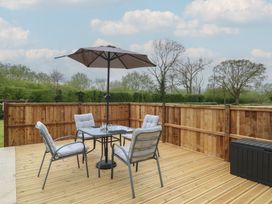 An outdoor dining area with a table and chairs at Aloe Lodge in Banham