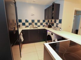 A kitchen with fridge, sink, oven and washing machine at 20 Lorton Street Cockermouth