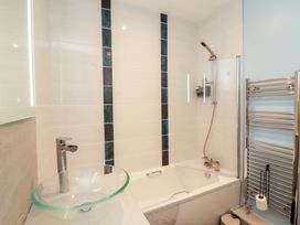 A bathroom with bathtub, shower, and sink at 20 Lorton Street in Cockermouth