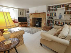 A living room with a tv and bookshelves at Crantock 