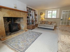A living room with a fireplace and bookshelf at Crantock