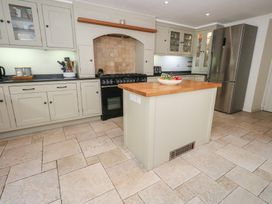 A kitchen with cabinets and a stove at Crantock in 