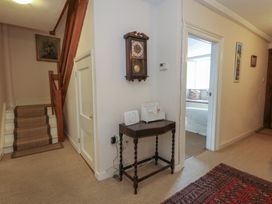 A hallway with a staircase and a clock at Crantock