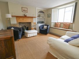 A living room with a fireplace and seating at Crantock