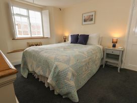 A bedroom with a bed and nightstand at Crantock