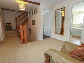 A hallway with a staircase and a mirror at Crantock