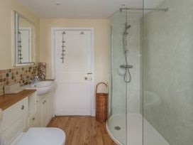 A bathroom with a shower, sink, and mirror at Crantock