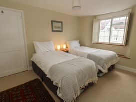 A bedroom with two single beds and a window at Crantock
