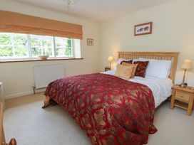A bedroom with a bed and nightstand at Crantock