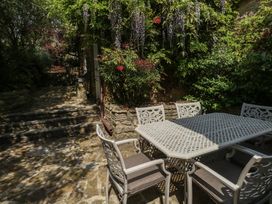 A garden with a table and chairs next to steps at Crantock