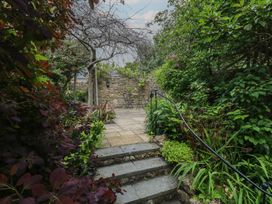 A garden with a pathway leading to a table and chairs at Crantock