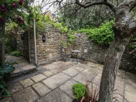 A garden with stone walls, a table and chairs at Crantock