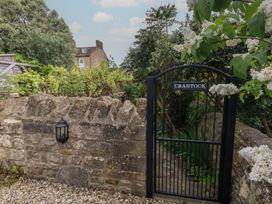 A garden gate leading to a path surrounded by plants at Crantock