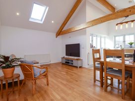 A living room with a sofa, table, and television at The Maisonette Hayle