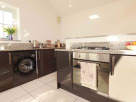A kitchen with washing machine and gas stove at The Maisonette in Hayle