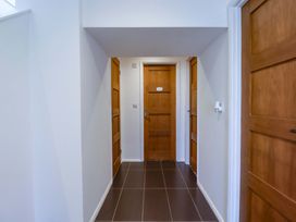 A hallway with three doors and floor tiles at The Maisonette in Hayle