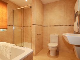 A bathroom with a shower, bathtub, toilet, and sink at The Maisonette in Hayle