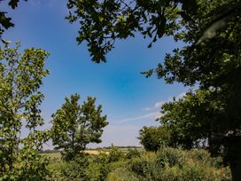 A view of trees and fields under a blue sky at Dave’s Place in Broadstone near Munslow