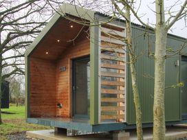 A cabin with wooden exterior and deck at Leafy Oak Lodge in Munslow