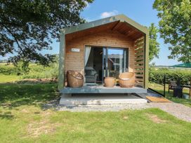 A cabin with a deck and seating area at Leafy Oaks Cabin in Munslow