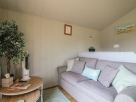 A living room with a sofa and coffee table at Leafy Oaks Cabin in Munslow